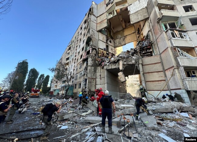 Firefighters and rescuers work at the site of an apartment building hit by a Russian air strike during Russia's attack on Kharkiv, Ukraine, Sept. 24, 2024.