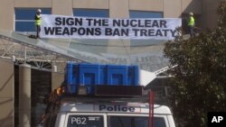 Two anti-nuclear weapons campaigners unfurl a banner, after they scaled the entrance awning of Australia's foreign ministry and onSept. 20, 2017, to protest the government's failure to endorse a United Nations' nuclear disarmament treaty. 