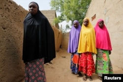 Amina Usman (L), a 15-year-old student, who was among those who escaped the attack on her school, stands with her sisters in Dapchi, Nigeria, Feb. 23, 2018.