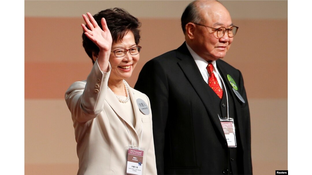 Carrie Lam waves after she won the election for Hong Kong's next Chief Executive as Woo Kwok-hing stands next to her in Hong Kong, March 26, 2017.
