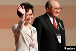 Carrie Lam waves after she won the election for Hong Kong's next Chief Executive as Woo Kwok-hing stands next to her in Hong Kong, March 26, 2017.