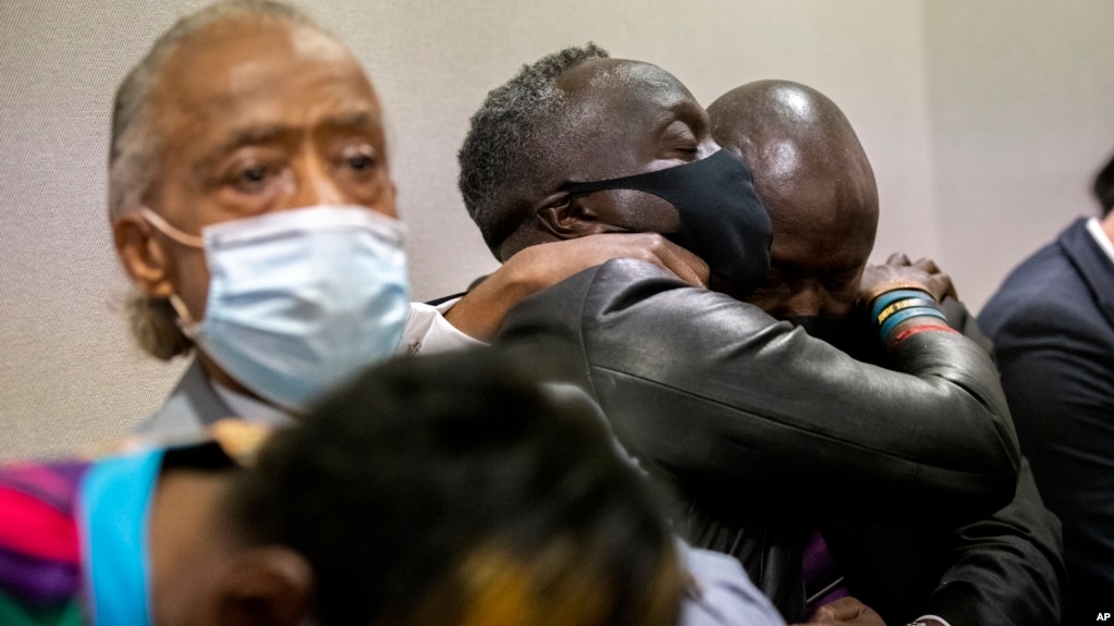 Ahmaud Arbery's father Marcus Arbery, center, his hugged by his attorney Benjamin Crump after the jury convicted Travis McMichael in the Glynn County Courthouse, Nov. 24, 2021, in Brunswick, Ga. (AP Photo/Stephen B. Morton, Pool)