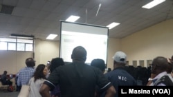 People watch results during a test of the Results Management System as votes trickled in from various constituency centers, at the main tallying center in Blantyre, Malawi.