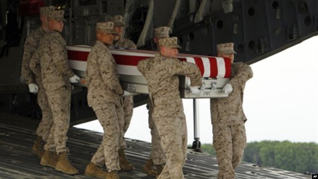Tim marinir membawa peti jenazah Cpl.Keaton G.Coffey dalam suatu upacara serah terima jenazah di Pangkalan Angkatan Udara Dover, Delaware (26/5). Coffey, salah satu tentara AS yang gugur dalam tugas di Afghanistan.