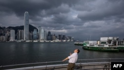 在超强台风“摩羯”经南中国海扑向中国南部海岸之际，一位男子在香港维多利亚港的长廊仰视天空。(2024年9月5日)