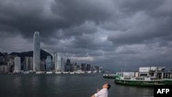 Seorang pria memandang ke arah langit di pelabuhan Victoria menjelang datangnya topan super Yagi yang melintas di sepanjang Laut China Selatan menuju pesisir China di bagian selatan, Kamis, 5 September 2024. (Foto: Dale De La Rey/AFP)