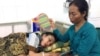 Indonesian maid Erwiana Sulistyaningsih is visited by her mother at a hospital on Java, Indonesia. (Ivan Broadhead/VOA)