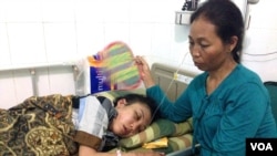 Indonesian maid Erwiana Sulistyaningsih is visited by her mother at a hospital on Java, Indonesia. (Ivan Broadhead/VOA)