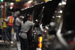 FILE - Factory employees are seen working in the plant of General Motors in the city of Silao, in the state of Guanajuato, Mexico, Nov. 25, 2008.