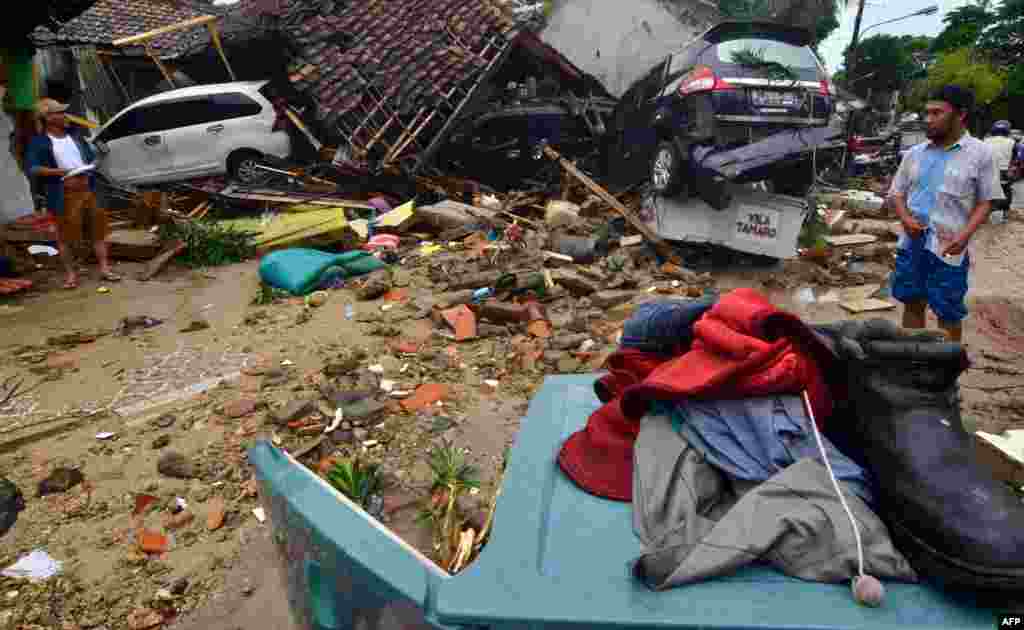 Warga memeriksa bangunan-bangunan yang rusak di Carita setelah kawasan tersebut dilanda tsunami pada Sabtu, 23 Desember 2018.