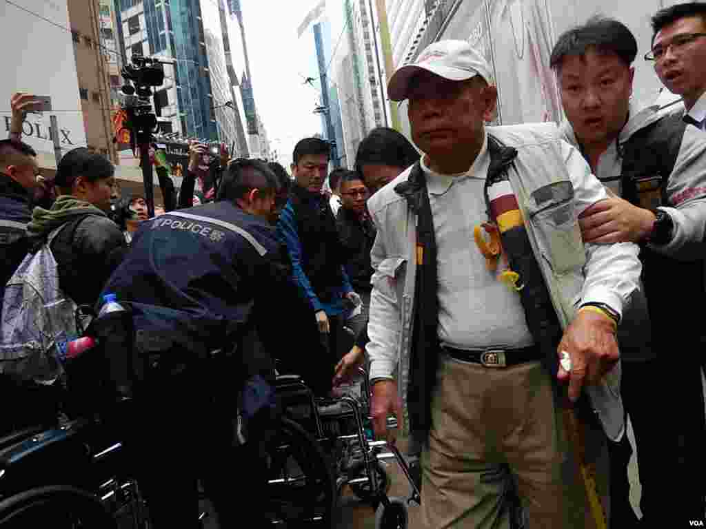 Mr. Wong stands up to be arrested, Hong Kong, Dec. 15, 2014. (Iris Tong/VOA)