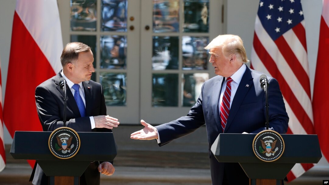 President Donald Trump and Polish President Andrzej Duda reach to shake hands at a news conference in the Rose Garden of the White House, in Washington, June 12, 2019. 