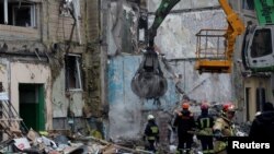Tim evakuasi bekerja di lokasi reruntuhan apartemen di Dnipro, Ukraina, yang hancur diserang rudal Rusia, pada 16 Januari 2023. (Foto: Reuters/Clodagh Kilcoyne)