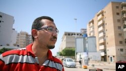 Wahabi Mohammed Yemeni stands at a checkpoint in his neighborhood in Tripoli, August 31, 2011