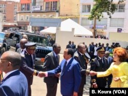 President Paul Biya greets officials as he arrives at his voting station at the primary public school of Bastos, Yaounde 1st district.