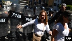 FILE - Supporters of the Venezuelan opposition confront members of the Bolivarian National Police as they attempted to block a main avenue during a protest against the government of President Nicolas Maduro, in Caracas, Venezuela, Nov. 18, 2019. 