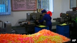 In this Oct. 22, 2018 photo, a worker monitors the production of sweets at Songdowon General Foodstuffs Factory in Wonsan, North Korea.