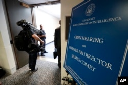 Media enter the hearing room where for former FBI director James Comey will testify before the Senate Intelligence Committee, on Capitol Hill, June 8, 2017, in Washington.