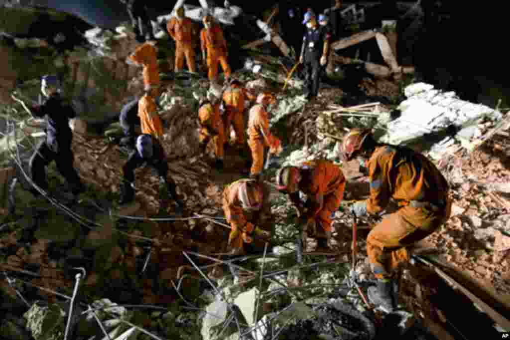 A Chinese search and rescue team works through the rubble of the collapsed headquarters of the United Nations mission in Haiti, 15 Jan 2010