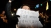 A person holds a placard that reads "Democracy will not surrender to Yoon Suk Yeol" as people gather outside the National Assembly, after South Korean President Yoon Suk Yeol declared martial law, in Seoul, South Korea, Dec. 4, 2024. 