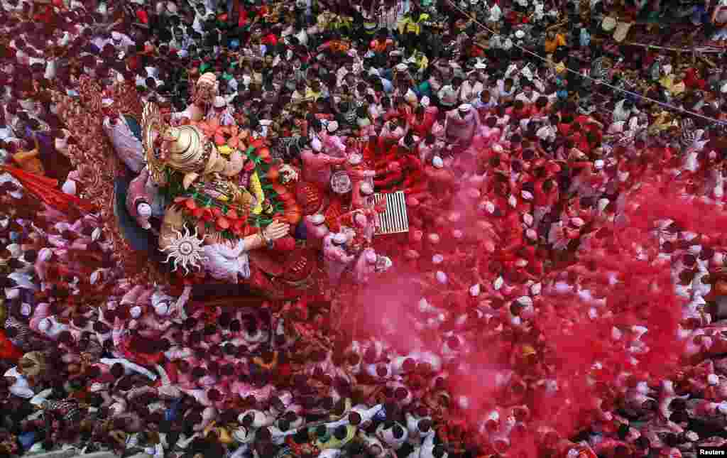 Ummat Hindu menggotong patung Dewa Ganesha, lambang kemakmuran, dalam festival agama Hindu di Mumbai, India.