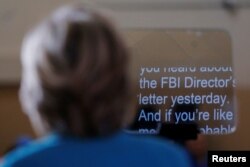 FILE - Then-U.S. Democratic presidential nominee Hillary Clinton reads from a tele-prompter as she speaks about the FBI inquiry into her emails during a campaign rally in Daytona Beach, Florida, Oct. 29, 2016.