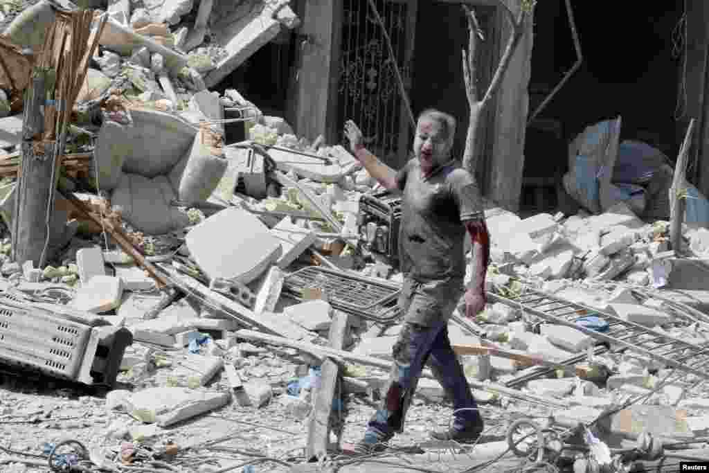 An injured man reacts in a damaged site after double airstrikes on the rebel held Bab al-Nairab neighborhood of Aleppo, Aug. 27, 2016.
