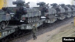 FILE - A German army soldier walks past Marder infantry fighting vehicles at the railway station in Sestokai, Lithuania, Feb. 24, 2017. 