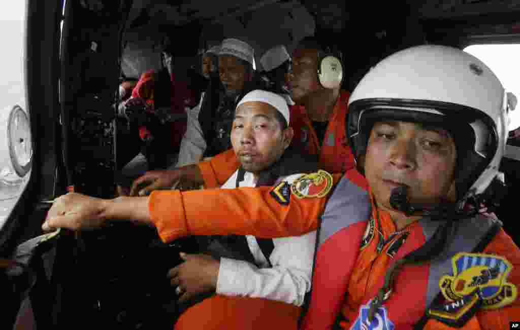 Para ulama berdoa untuk para korban jatuhnya pesawat AirAsia dalam helikopter yang melintasi Laut Jawa (6/1). (AP/Achmad Ibrahim)