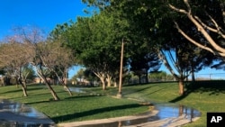 Sprinklers water grass at a park on April 9, 2021, in the Summerlin neighborhood of Las Vegas. 