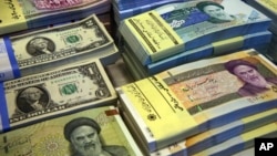 FILE- Iranian and U.S. banknotes are on display at a currency exchange shop in downtown Tehran, Iran, April 4, 2015.