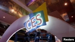 Workers hang signage in the lobby of the Las Vegas Convention Center as they prepare for the 2017 International CES technology trade show in Las Vegas, Nevada, Jan. 3, 2017.