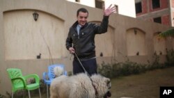 FILE - Baher Mohamed, an Al-Jazeera journalist recently released, waves at his children at his home in 6 October city, a suburb southwest of Cairo, Egypt, Saturday, Feb. 14, 2015.