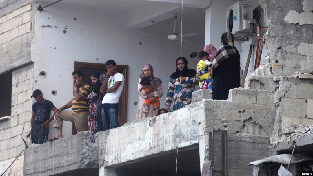 Residents inspect damage after shelling that activists attribute to forces loyal to Syrian President Bashar al-Assad, Raqqa province, May 2, 2013.