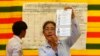 FILE - An election official shows a ballot paper as votes are counted at a polling station in Phnom Penh, July 28, 2013.