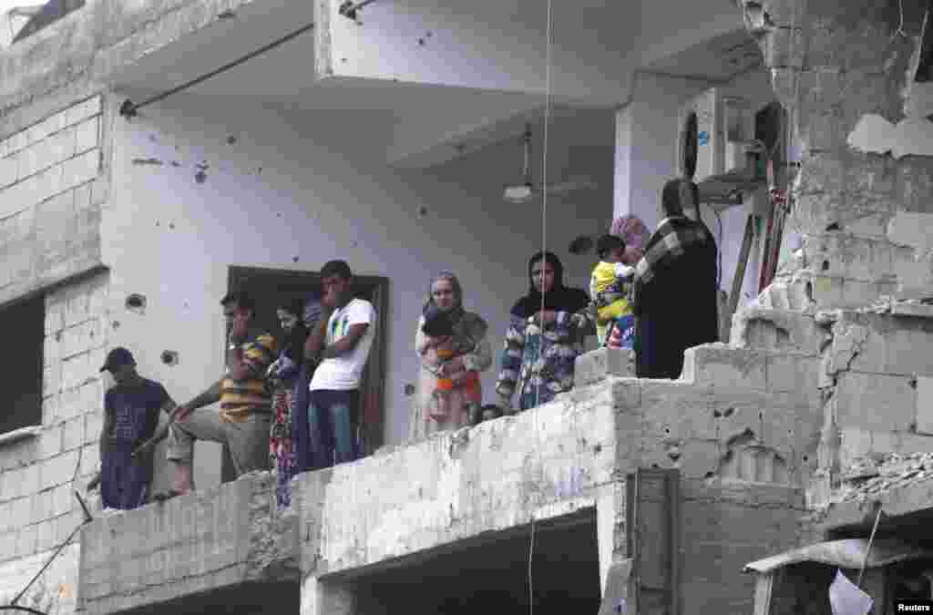 Residents inspect a damaged building that was shelled by forces activists say were loyal to Syrian President Bashar al-Assad, Raqqa province, Syria, May 2, 2013.