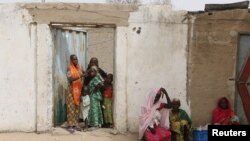 Des femmes observent une patrouille militaire camerounaise à Kerawa, au Cameroun, à la frontière avec le Nigeria, le 16 mars 2016.