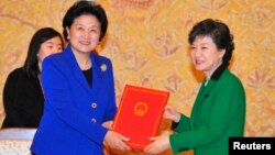 박근혜 한국 대통령(오른쪽)이 지난 2월 취임 직후 청와대에서 류엔둥 중국 국무위원으로부터 당시 후진타오 주석과 시진핑 당 총서기의 친서를 전달 받았다.