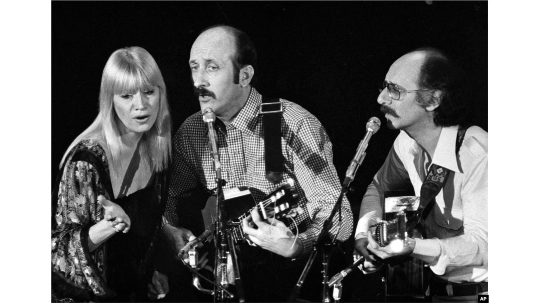 FILE - Folk trio Peter, Paul and Mary, from left, Mary Travers, Paul Stookey and Peter Yarrow, perform at a Los Angeles benefit to aid to Cambodian refugees on Jan. 30, 1980.