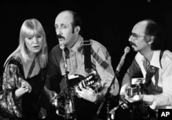 FILE - Folk trio Peter, Paul and Mary, from left, Mary Travers, Paul Stookey and Peter Yarrow, perform at a Los Angeles benefit to aid to Cambodian refugees on Jan. 30, 1980.