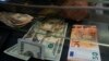 Seorang kasir menukar uang kertas 50 Euro dengan dolar AS di loket penukaran uang di Roma, Rabu, 13 Juli 2022. Untuk pertama kalinya sejak 2002 nilai euro hampir setara dengan nilai dolar. 