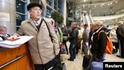 Passengers, whose flights to Egypt were suspended, gather at an information desk of Domodedovo airport outside Moscow, Russia, Nov. 6, 2015.