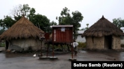 Une boîte aux lettres donnée par la société minière Rio Tinto devant des huttes à l'extérieur de Beyla, en Guinée, le 5 juin 2014.