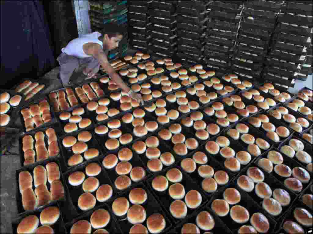 A boy arranges bread for sale after baking them in an oven at a workshop in Lahore.