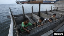 Anak-anak menggunakan toilet dari kayu di daerah kumuh dekat pelabuhan Jakarta Utara. (Reuters/Beawiharta)