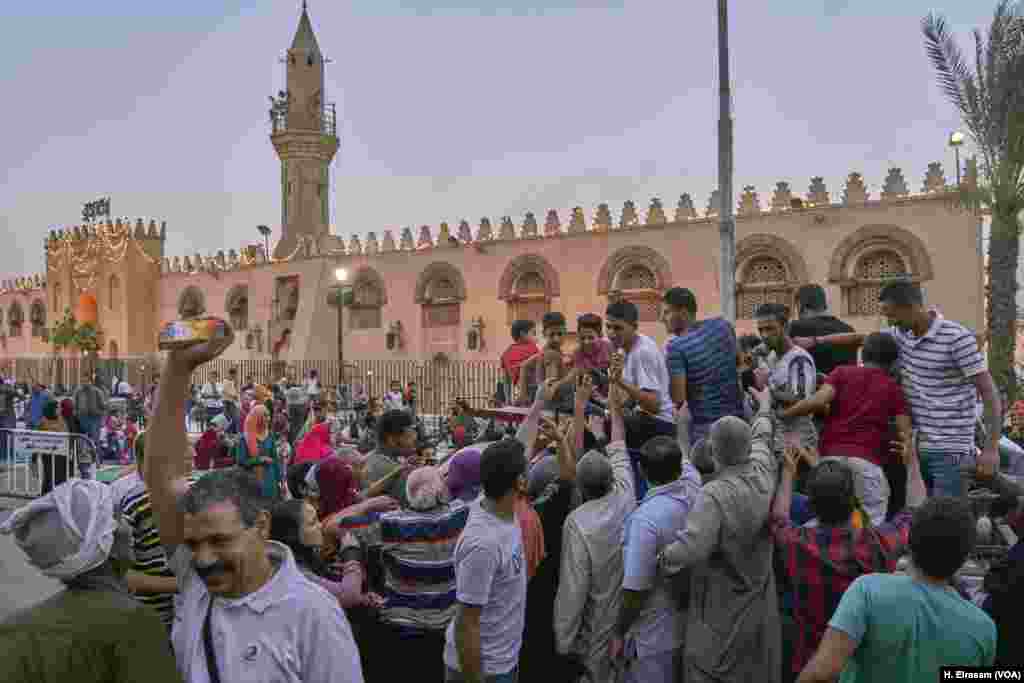 People distribute food, water and drinks to Muslims coming to attend the prayers at Amr Ibn al-As mosque, in old Cairo, Egypt, May 31, 2019.