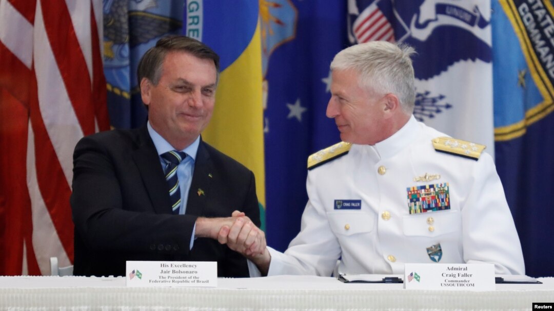 Presiden Brazil Jair Bolsonaro (kiri) dan Laksamana AS Craig Faller menandatangani perjanjian pertahanan Brazil-AS di Miami, Florida, Minggu (8/3). 