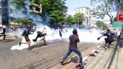 Imagen sacada de un video de manifestantes en Rangún, Myanmar, luchando contra gases lagrimógenos lanzados por las fuerzas de seguridad el 1 de marzo de 2021.