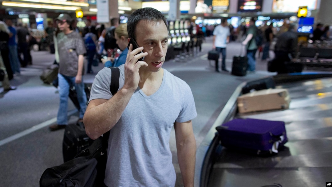 Seorang penumpang menelepon saat mengambil bagasinya di Bandara Internasional McCarran International di Las Vegas. (AP/Julie Jacobson)