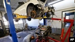 FILE - Automotive technicians Don Dimond, left, and Bernie Rabinovitz work in a repair shop in Harmony, Pa. The average age of cars and trucks in the U.S. has hit 11.8 years, as better quality and technology allows people to keep them on the road longer.